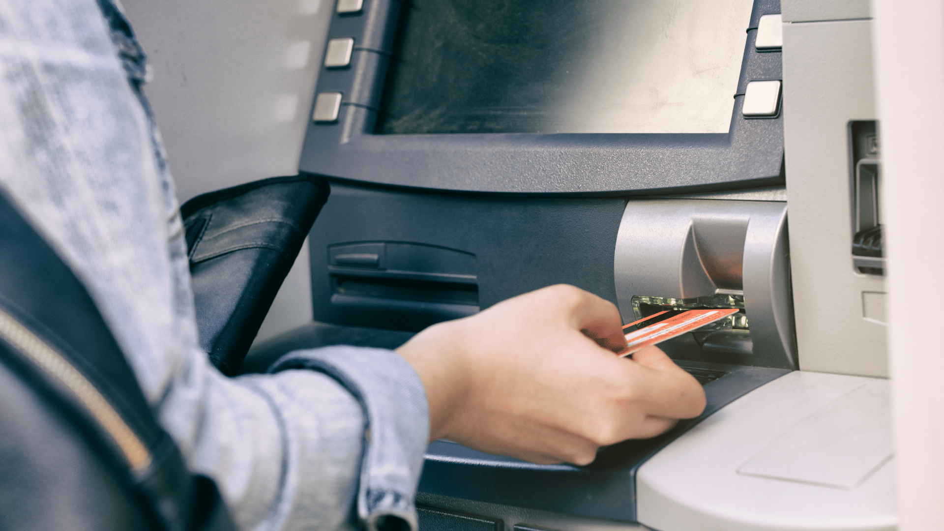 Person inserting a card into an ATM