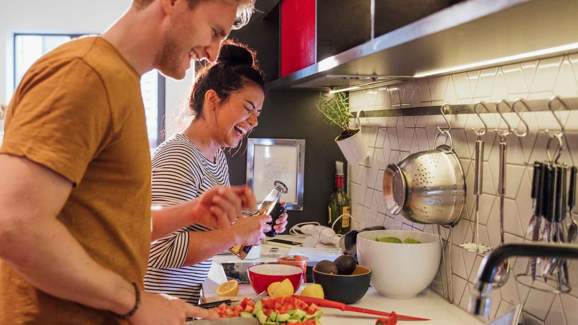 couple laughs in kitchen