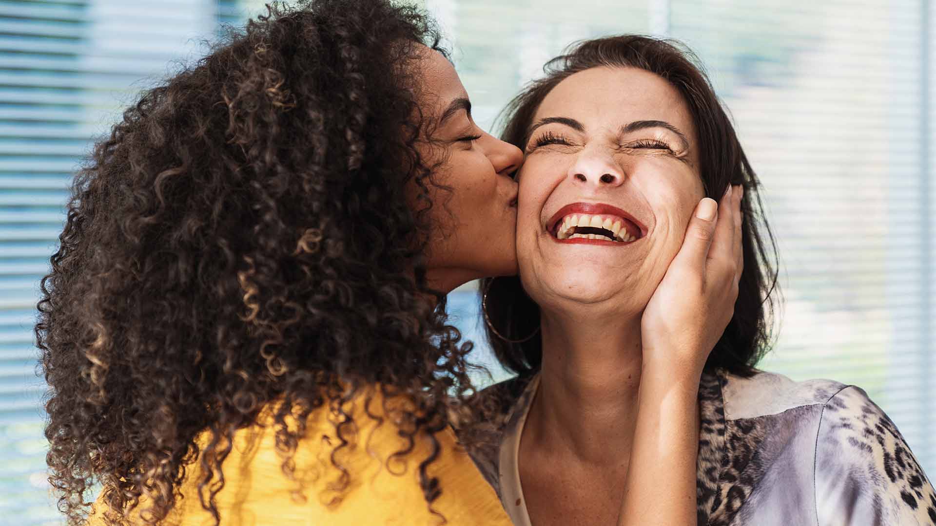 Daughter kissing mom on the cheek