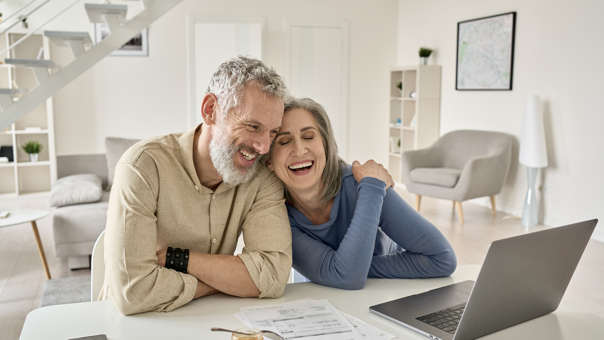 Happy couple reviewing finances on laptop