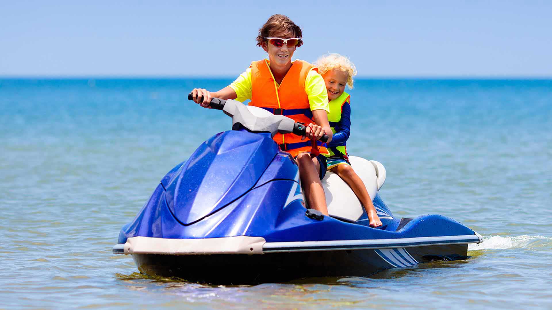 Kids wearing life vest on jet ski