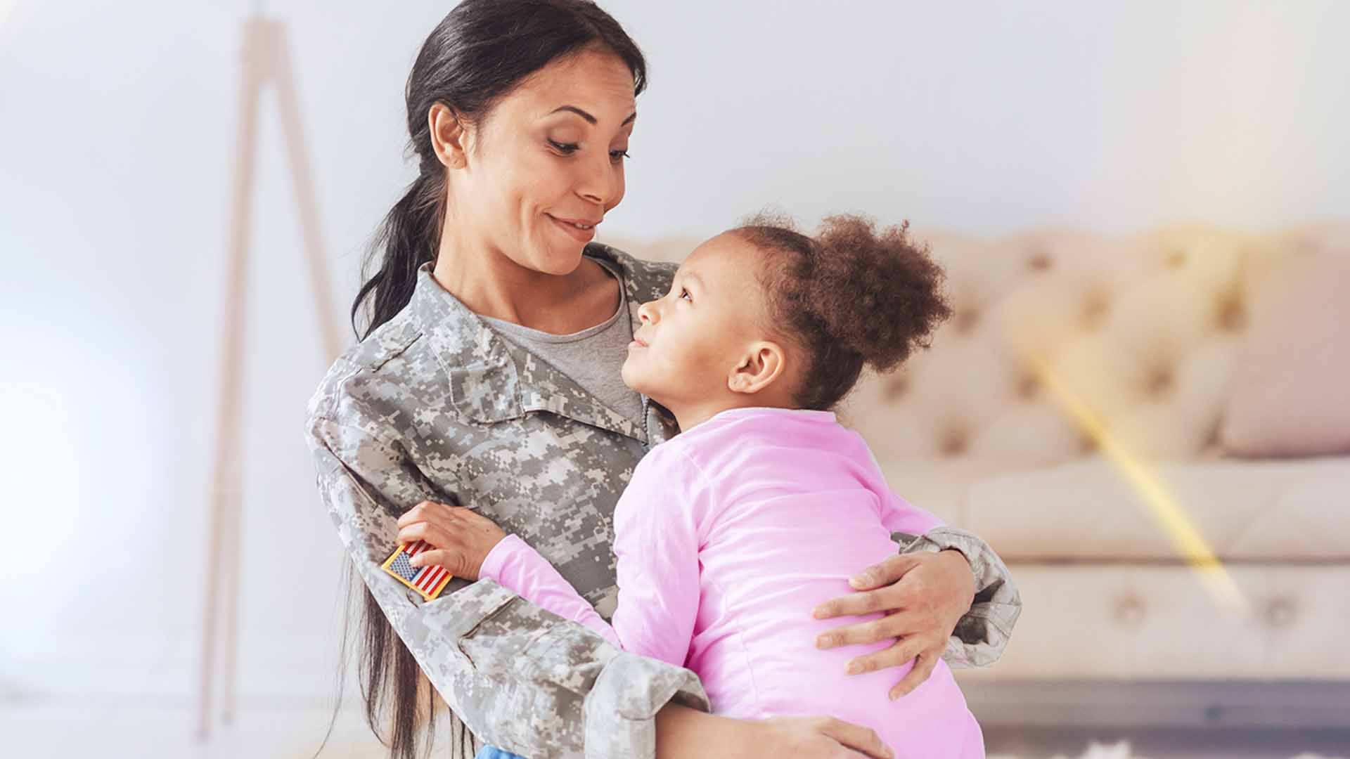 Military Mom hugging daughter at home