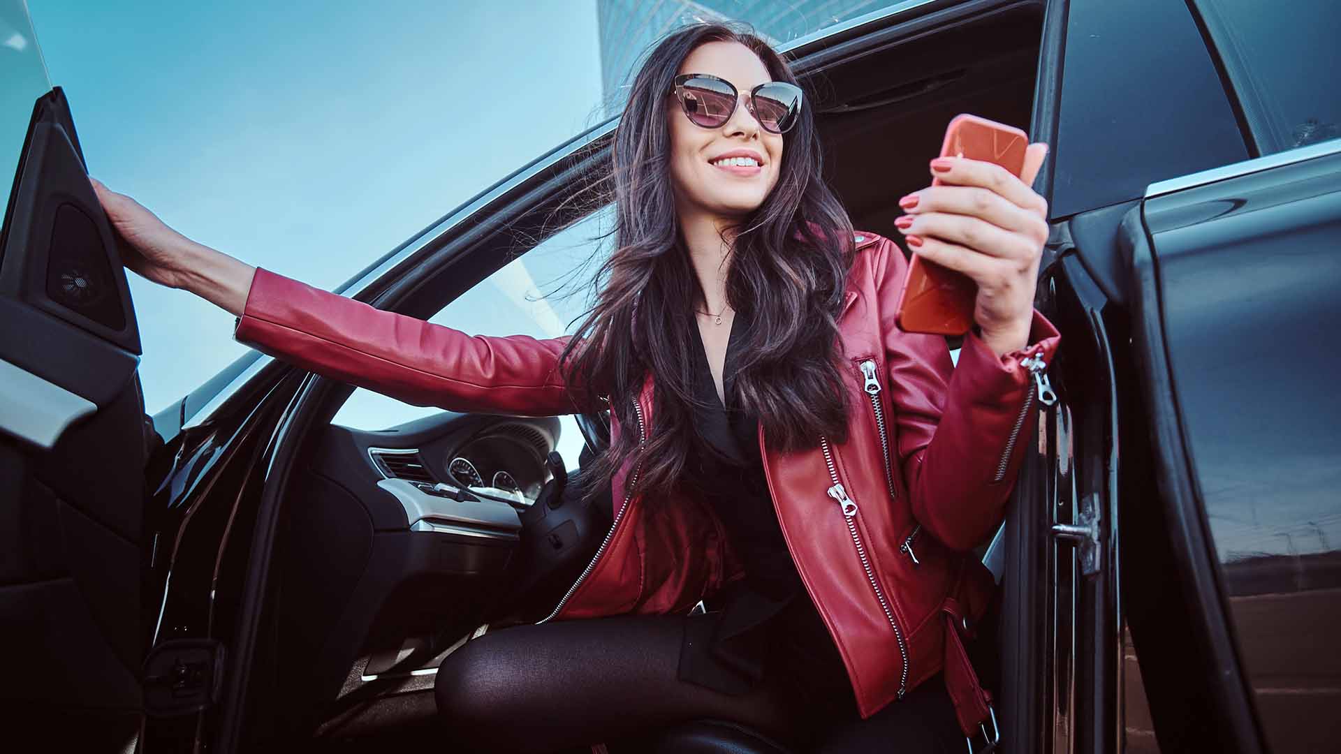 Woman exiting car holding phone