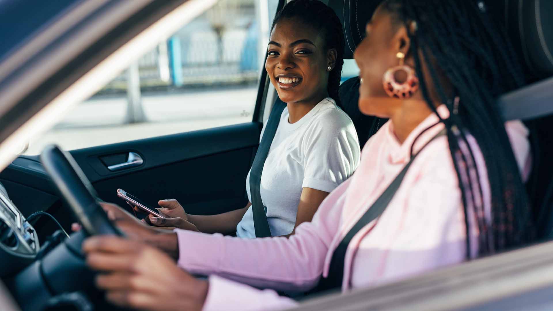 women driving and smiling