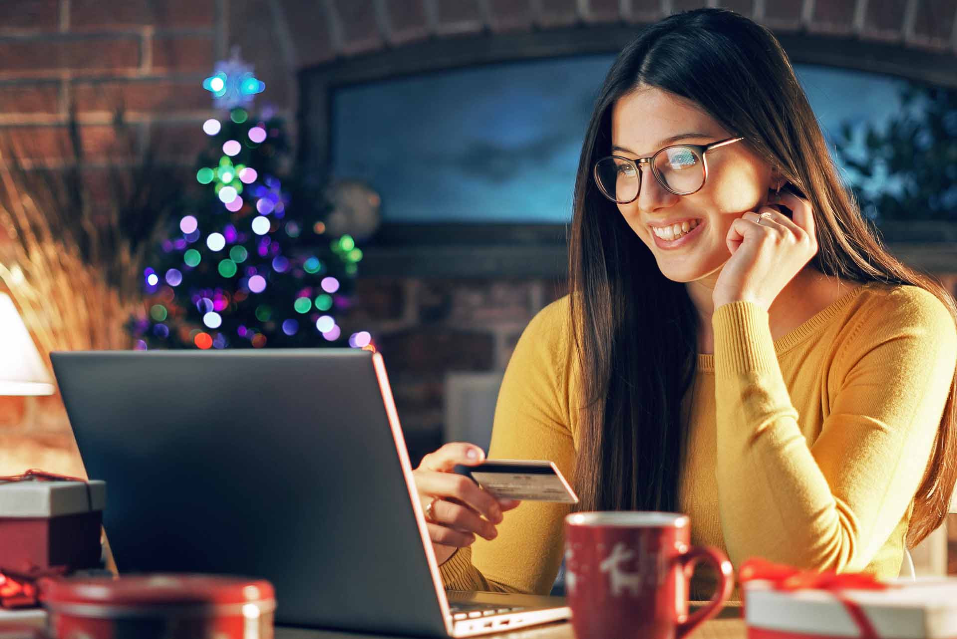 Young woman with glasses shopping online for holiday gifts