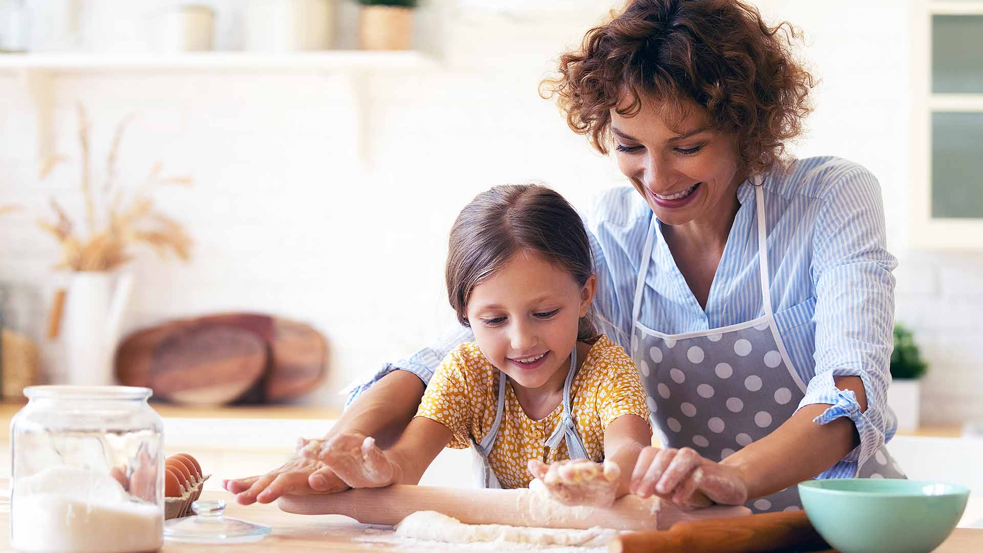 Mother and Young Daughter Baking in home kitchen
