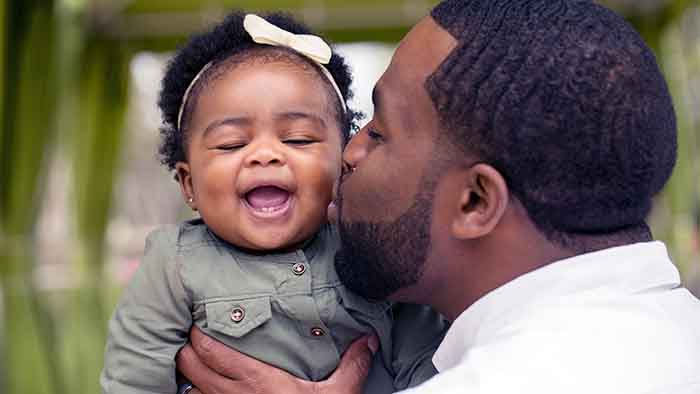 Father kissing happy baby on cheek